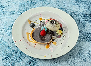 baked chocolate tart topping with strawberry and blackberry served in plate isolated on background top view of italian food