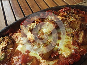 Baked chopped chicken and garnish in ceramics pot