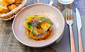 Baked coalfish fillet with quinoa, curry and fresh vegetables
