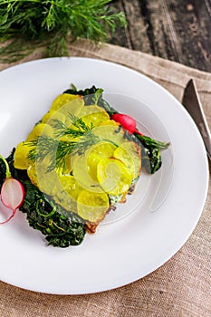 Baked cod with potatoes on a white plate on a rustic napkin