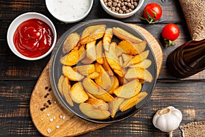 Baked country style potatoes in black pan with sauce