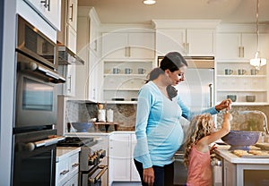 Baked with double the love. a little girl helping her mother bake cookies at home.