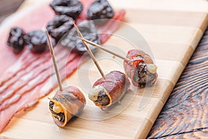 Baked dried plums filled with cheese and bacon rolled, snack or appetizer