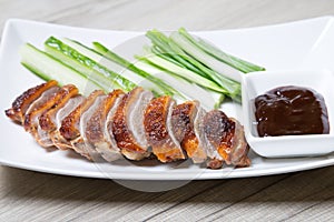 Baked duck with hoisin sauce, cucumbers and shallots.