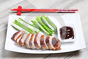 Baked duck with hoisin sauce, cucumbers and shallots.