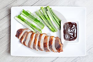 Baked duck with hoisin sauce, cucumbers and shallots.