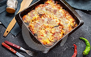 Baked eggplant with cheese on a stone table. Parmigiana melanzane. Italian cuisine.