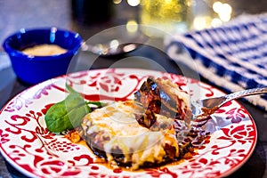 Baked Eggplant Parmagiana on red and white plate, gluten free - no egg or breadcrumbs.