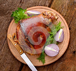 Baked Eisbein with wegetables on wooden board