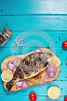 Baked fish dorado. Sea bream or dorada fish grilled on a blue wooden background. Top view with copy space