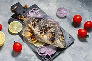 Baked fish dorado. Sea bream or dorada fish grilled on a concrete background