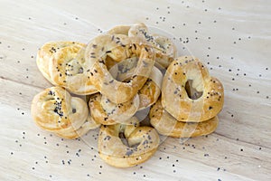 Baked fresh pretzels on wooden table, heart and twisted knot shapes, covered with poppy seeds salt and caraway seeds