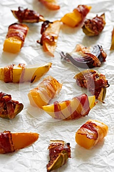 Baked fruit and vegetable assorti wrapped with bacon photo