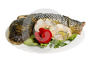 Baked gefilte fish with greens on the plate, isolated