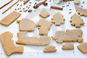 Baked gingerbread cookies for christmas 3D composition on wooden table, spices on background