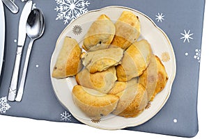 Baked golden dumplings in a pie lying on a holiday table on a plate, isolated on a white background with a clipping path, top view