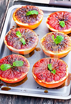 Baked grapefruit with brown sugar and cinnamon on metal tray