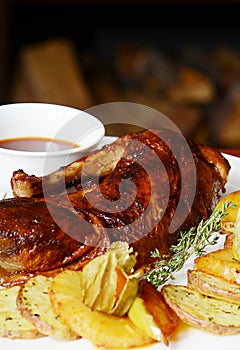 Baked half of duck with a potato, apples and pineapple
