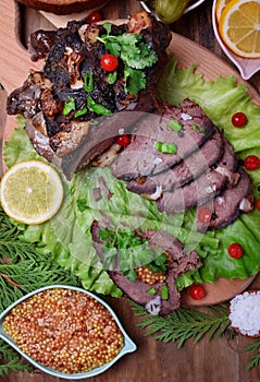 Baked ham of elk meat cut into slices topped with greenery and cranberries