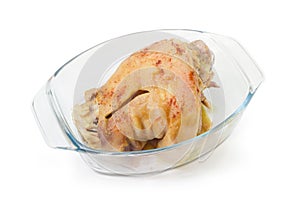 Baked ham hock in glass casserole pan on white background