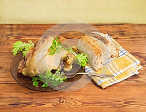 Baked ham hock on glass dish on wooden surface