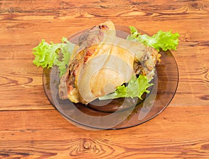 Baked ham hock on glass dish on wooden surface