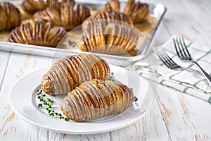 Baked hasselback potato. An accordion baked potato with garlic, thyme and sea salt. Delicious vegetarian food