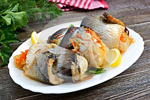 Baked herring stuffed with vegetables. Tasty fish rolls