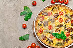 Baked homemade quiche pie in ceramic baking form on concrete background