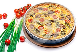 Baked homemade quiche pie in ceramic baking form on concrete background