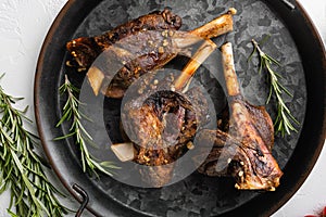 Baked lamb shank meat, on white stone table background, top view flat lay