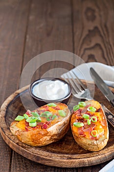 Baked loaded potato skins with cheddar cheese and bacon, garnish