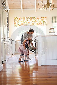 Baked with love. a little girl baking with her mother in the kitchen.