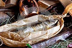 baked mackerel in a paper bag on a wooden board