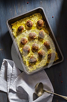 Baked meat balls with creamy sauce in a frying pan above