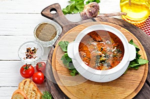 Baked meat with potatoes and vegetables in a bowl. Ukrainian traditional cuisine. Top view.