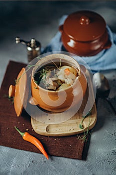 baked meat with vegetables in a clay pot served for dinner photo