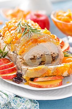 Baked meatloaf stuffed with apples and plums, decorated tangerine confiture. Christmas menu