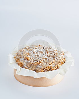 Baked mini crumble cake on recycle Mini Wooden Baking Mold, white background, copy space, selective focus. Homemade pastry,