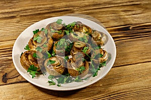 Baked mushrooms in plate on wooden table