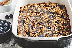 Baked oatmeal with blueberries and honey in oven dish. Oatmeal fruit crumble pie