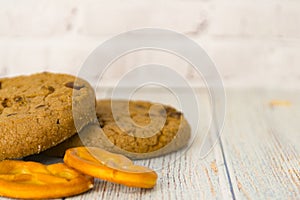 Baked oatmeal cookies and bagel lie on a light wooden table. There is a place for text. Concept breakfast, holiday, cooking