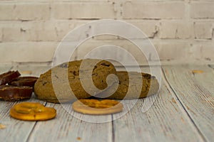 Baked oatmeal cookies and bagel lie on a light wooden table. There is a place for text. Concept breakfast, holiday, cooking