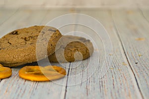 Baked oatmeal cookies and bagel lie on a light wooden table. There is a place for text. Concept breakfast, holiday, cooking