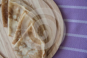 Baked pancakes on lilac tablecloth