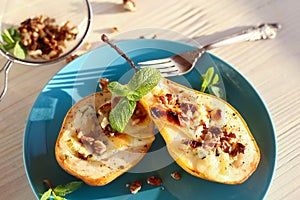 Baked pears with dor blue cheese on a blue plate