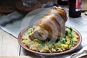 Baked pork knuckle served with stewed cabbage and beer. Rustic style