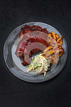 Baked pork knuckle with vegetables. Cabbage salad. Homemade grilled potatoes. Traditional beer snack. Vertical photo.Top