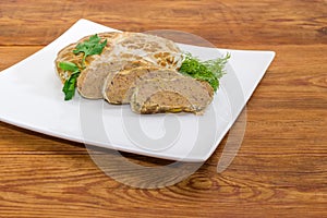 Baked pork liver pate on dish on rustic table closeup