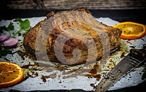 Baked pork ribs with sauce and basil on a black table. Top view. Close-up. Selective focus